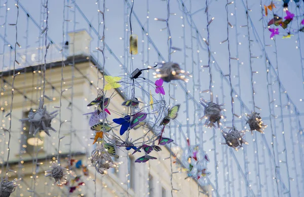 Glowing lanterns and garlands on the street in the background of houses. Nikolskaya street, Moscow