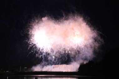Göl üzerinde Festival havai fişekler. duman ve sis bulutu içinde çok renkli ışıklar. Güzel yansıma su. Ukrayna.