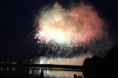Göl üzerinde Festival havai fişekler. duman ve sis bulutu içinde çok renkli ışıklar. Güzel yansıma su. Ukrayna.