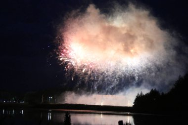 Göl üzerinde Festival havai fişekler. duman ve sis bulutu içinde çok renkli ışıklar. Güzel yansıma su. Ukrayna.