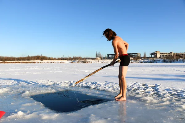 赤ひげと長髪 黒のショート パンツで 裸で若い スリム ハンサムなスポーティな男 ウクライナに産業景観の背景に 冬の冷たい水に飛び込む — ストック写真