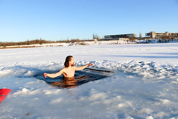 Un joven se prepara para sumergirse en el agujero de hielo. Invierno, frío, aguas abiertas . — Foto de Stock