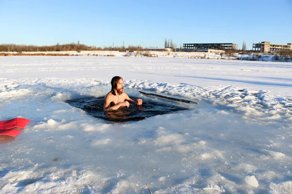 若い男が氷の穴に飛び込む準備をしている。冬、寒さ、開いている水. — ストック写真