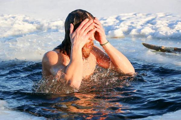 若い男が氷の穴に飛び込む準備をしている。冬、寒さ、開いている水. — ストック写真