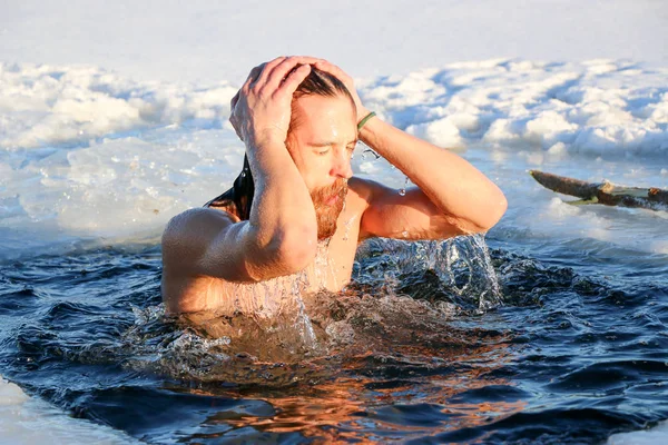 Ein junger Mann bereitet sich darauf vor, in das Eisloch zu tauchen. Winter, Kälte, offenes Wasser. — Stockfoto
