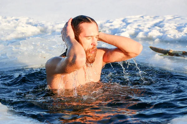Genç bir adam buz çukuruna dalmaya hazırlanıyor. Kış, soğuk, açık deniz. — Stok fotoğraf
