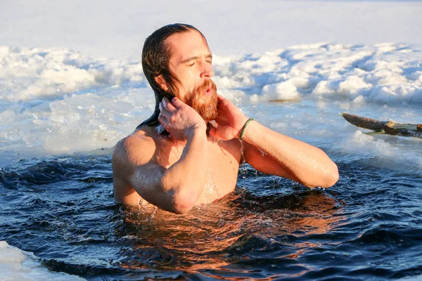 Un giovane uomo si sta preparando a tuffarsi nella buca di ghiaccio. Inverno, freddo, acqua aperta . — Foto Stock