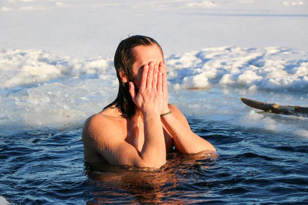 En ung man förbereder sig för att dyka ner i ishålet. Vinter, kallt, öppet vatten. — Stockfoto