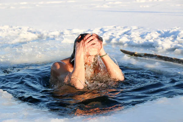 Un joven se prepara para sumergirse en el agujero de hielo. Invierno, frío, aguas abiertas . — Foto de Stock