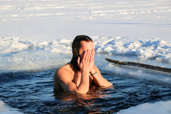 若い男が氷の穴に飛び込む準備をしている。冬、寒さ、開いている水. — ストック写真