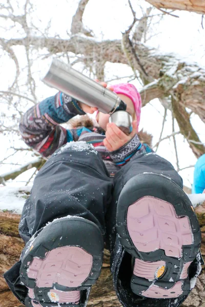 Junge Liegeplatz Mann mit kleinem Mädchen haben Spaß im verschneiten Wald im Winter. — Stockfoto