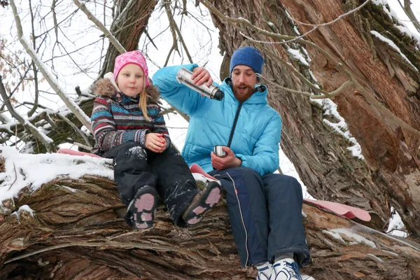 Ung, beruset mann med en liten jente morer seg i snødekt skog om vinteren . – stockfoto