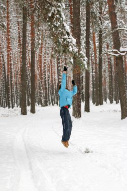 Kış çam ormanı içinde kırmızı sakallı neşeli yakışıklı bir genç adam portresi. Bir kış günü kar çam şubesinden patlatmış. Uzun boylu bir çamları. dikey odaklı