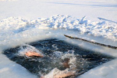 Parlak güneşli bir günde, bir karlı manzara karşı Kışın buzlu suya dalış bir genç, ince, yakışıklı, atletik ve güçlü adam, çıplak, güzel birçok damla ve su sıçramalarına. Ukrayna, Shostka
