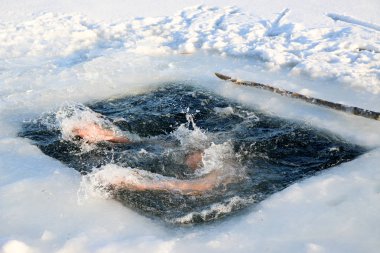 Parlak güneşli bir günde, bir karlı manzara karşı Kışın buzlu suya dalış bir genç, ince, yakışıklı, atletik ve güçlü adam, çıplak, güzel birçok damla ve su sıçramalarına. Ukrayna, Shostka