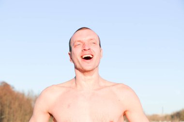 Genç iyi seyir ve çekici adam ile kas bir buz banyosu aldıktan sonra alarak vücut. yakışıklı çekici erkek yüzme havuzu yanında duş. su damlaları onun Gövde üzerinde düşer. Güneşli kış günü Ukrayna, Shostka