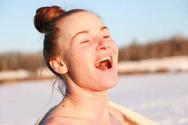 美しい少女 赤髪の女の笑顔し 美しい晴れた日に湖畔に冬で泳いだ後日光浴を楽しみます 雪景色と青空の背景です ウクライナ スミ州ショ — ストック写真