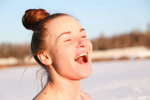 美しい少女 赤髪の女の笑顔し 美しい晴れた日に湖畔に冬で泳いだ後日光浴を楽しみます 雪景色と青空の背景です ウクライナ スミ州ショ — ストック写真