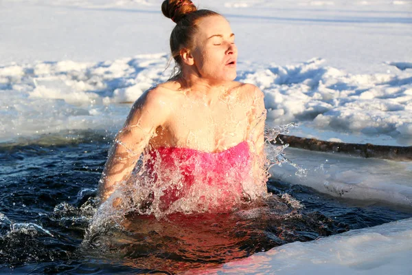 側ワンピース水着で 赤い髪の美しい少女 水に飛び込み氷冬の湖の美しい晴れた日に ウクライナ スミ州ショ — ストック写真
