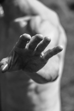 Erkek eli, kaslı bir adamın siyah-beyaz görüntüsü, atletik vücut, kasların güzel erkeksi biçimleri, rahatlama. Güzel güçlü ve esnek vücut, seksi cazibe.