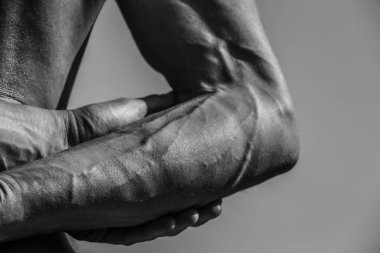 Erkek eli, kaslı bir adamın siyah-beyaz görüntüsü, atletik vücut, kasların güzel erkeksi biçimleri, rahatlama. Güzel güçlü ve esnek vücut, seksi cazibe.