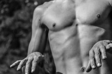 Erkek eli, kaslı bir adamın siyah-beyaz görüntüsü, atletik vücut, kasların güzel erkeksi biçimleri, rahatlama. Güzel güçlü ve esnek vücut, seksi cazibe.