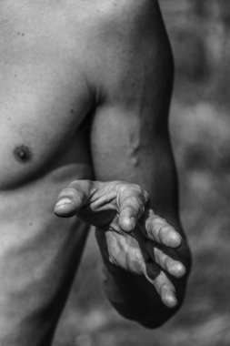 Erkek eli, kaslı bir adamın siyah-beyaz görüntüsü, atletik vücut, kasların güzel erkeksi biçimleri, rahatlama. Güzel güçlü ve esnek vücut, seksi cazibe.