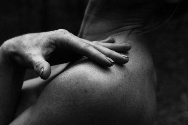 Güzel bir kadının çıplak bir vücudun arka planında, arka omuzlarında, basit ve doğal bir pozda siyah beyaz bir fotoğrafının zarif pozu..