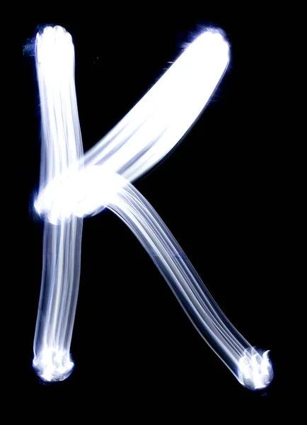 Handwrite letter K, made with light painting technic isolated on black. Light effect font of full alphabet set of upper case letters.