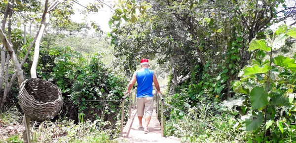Vecchio che attraversa un piccolo ponte fiorito a Itamatamirim, interno di Pernambuco, Brasile . — Foto Stock
