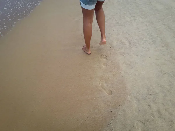 Woman walking on sand beach leaving footprints in the sand. Closeup detail of female feet at Brazil. — Stock Photo, Image