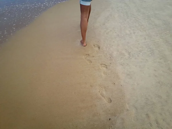 Vrouw lopen op zand strand verlaten voetafdrukken in het zand. Close-up detail van vrouwelijke voeten in Brazilië. — Stockfoto