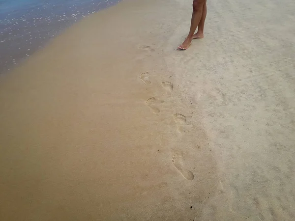 Frau, die am Sandstrand spaziert und Spuren im Sand hinterlässt. Nahaufnahme Detail weiblicher Füße in Brasilien. — Stockfoto