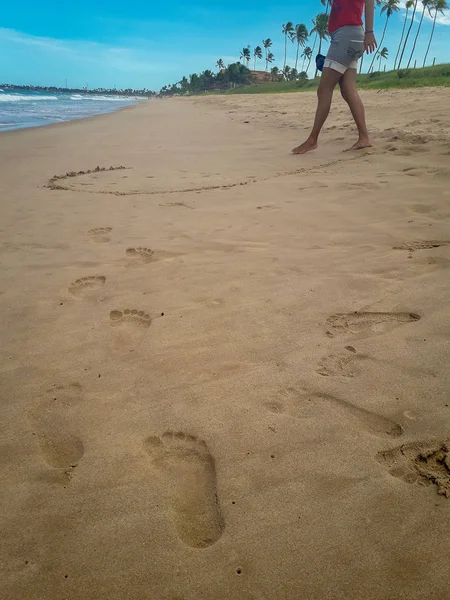Mujer caminando en la playa de arena dejando huellas en la arena. Detalle de primer plano de los pies femeninos en Brasil . — Foto de Stock