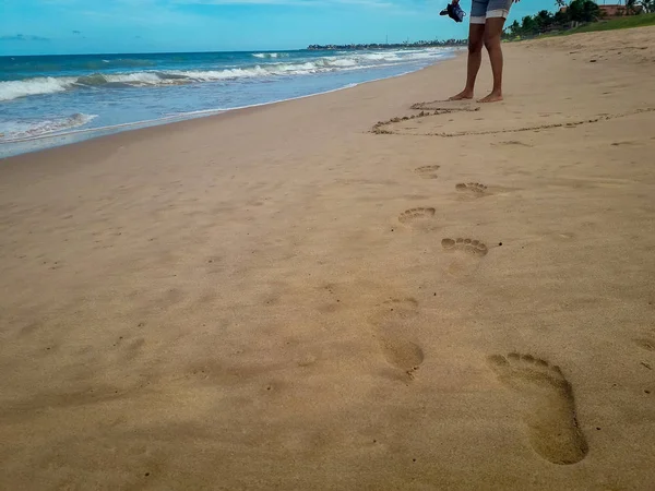 Жінка вигулює на білопіщаному пляжі, залишаючи слідів на піску. Крупним планом докладно жіночий футів в Бразилії. — стокове фото