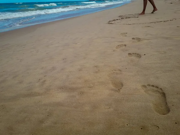 Vrouw lopen op zand strand verlaten voetafdrukken in het zand. Close-up detail van vrouwelijke voeten in Brazilië. — Stockfoto