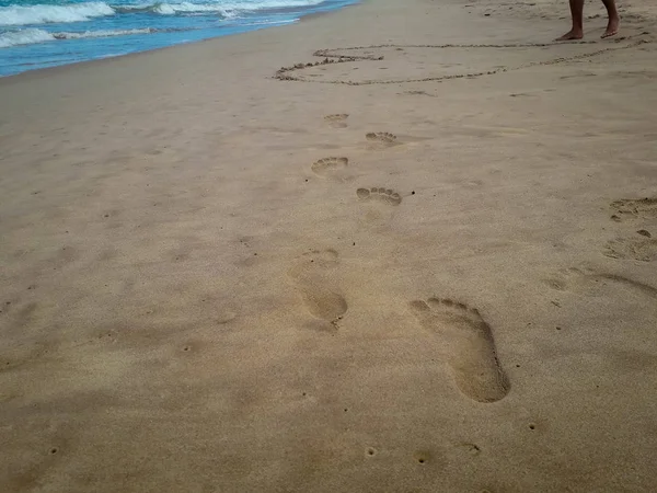 Vrouw lopen op zand strand verlaten voetafdrukken in het zand. Close-up detail van vrouwelijke voeten in Brazilië. — Stockfoto