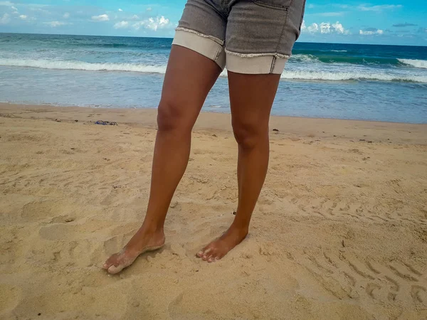 Woman walking on sand beach leaving footprints in the sand. Closeup detail of female feet at Brazil. Stock Photo