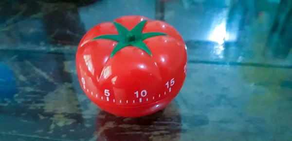 Pomodoro timer em mesa de madeira com fundo escuro desfocado . — Fotografia de Stock