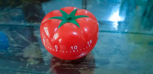 Pomodoro časovač v dřevěný stůl s rozmazané pozadí.. — Stock fotografie