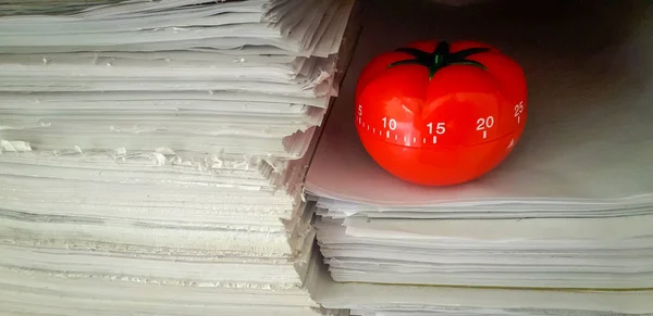 Temporizador Pomodoro em fundo de texturas de papel empilhadas . — Fotografia de Stock