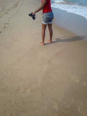 Kumda ayak izleri bırakarak kum plajı üzerinde yürüyen kadın. Brezilya kadın ayak detay.