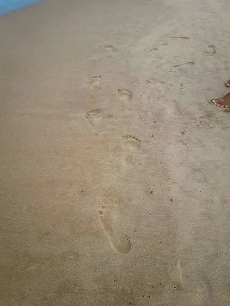 砂の足跡を残す砂浜の上を歩く女性。ブラジルでの女性の足のクローズ アップの詳細. — ストック写真