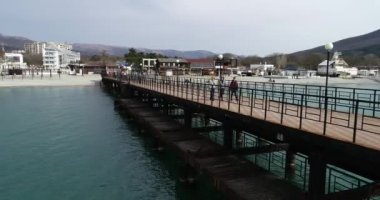 Gelendzhik kasabasının yakınındaki Kabardinka köyü. Kabardinki 'e ait bir yer. Minyatürler sokak görünümü. Gemi sular altında. Dönme dolabı. Sahil taşları. Sahil dalgası. Karadeniz. Gemi kargo gemisi. Rusya. Krasnodar bölgesi. Video