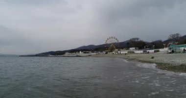 Gelendzhik kasabasının yakınındaki Kabardinka köyü. Kabardinki 'e ait bir yer. Minyatürler sokak görünümü. Gemi sular altında. Dönme dolabı. Sahil taşları. Sahil dalgası. Karadeniz. Gemi kargo gemisi. Rusya. Krasnodar bölgesi. Video