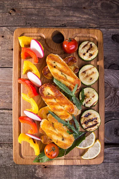 Peynir ve aperatifler koleksiyonu ayarla. Izgara Hellim, biber, zuccini ve eski ahşap rustik arka plan üzerinde üzerinde turp. Ek yük. 