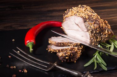 Parça ve kavrulmuş et dilimleri. Soğuk haşlanmış pişmiş domuz koyu arka plan üzerine hardal taneleri ile.