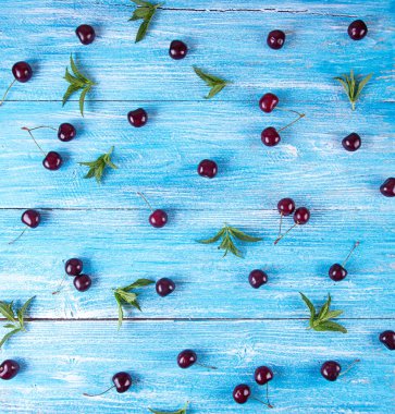 Taze tatlı kiraz ile mavi ahşap arka plan.
