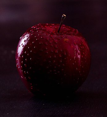 Kırmızı elma suyu ile siyah arka plan üzerine bırakır. Karanlık tarzı.