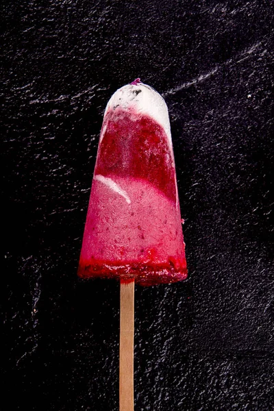 Strawberry ice cream popsicle lolly pops with whipped cream on b